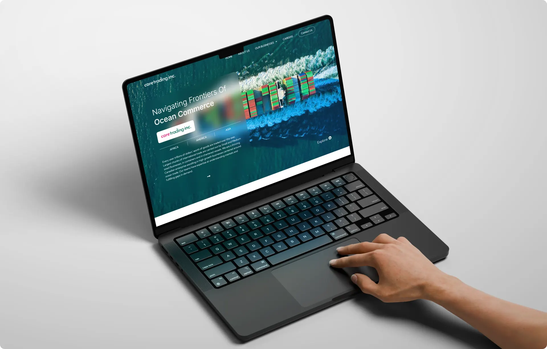 A tilted laptop on a plain background showing the Care Trading home page, with a hand resting on the trackpad.