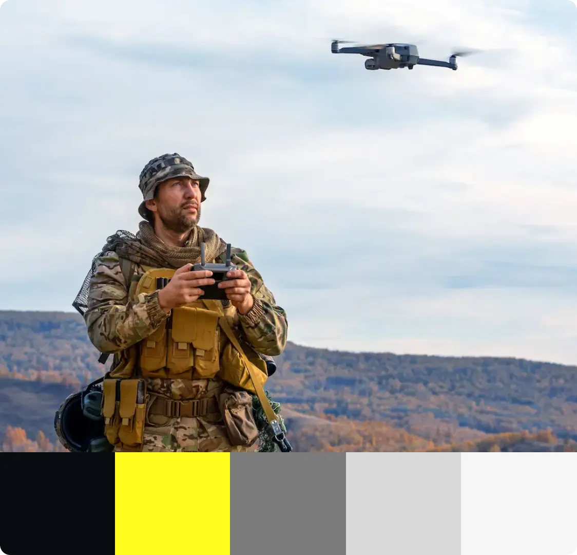 A photograph of a drone pilot holding a controller outdoors, with a five-colour swatch strip across the bottom.