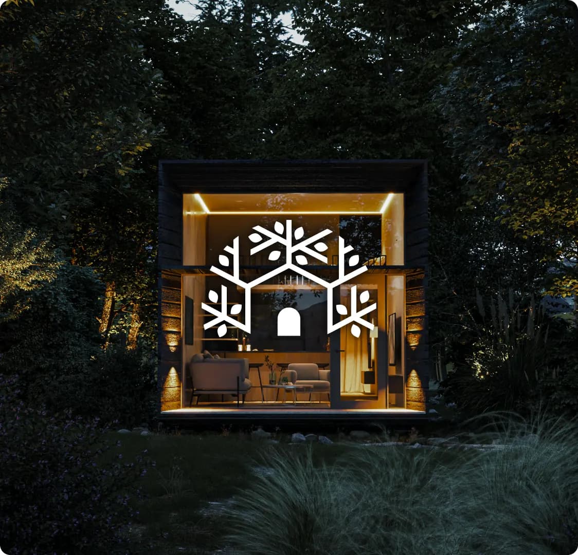 A lit cabin at night in dense forest, with the Nestable snowflake mark laid over the middle of it.