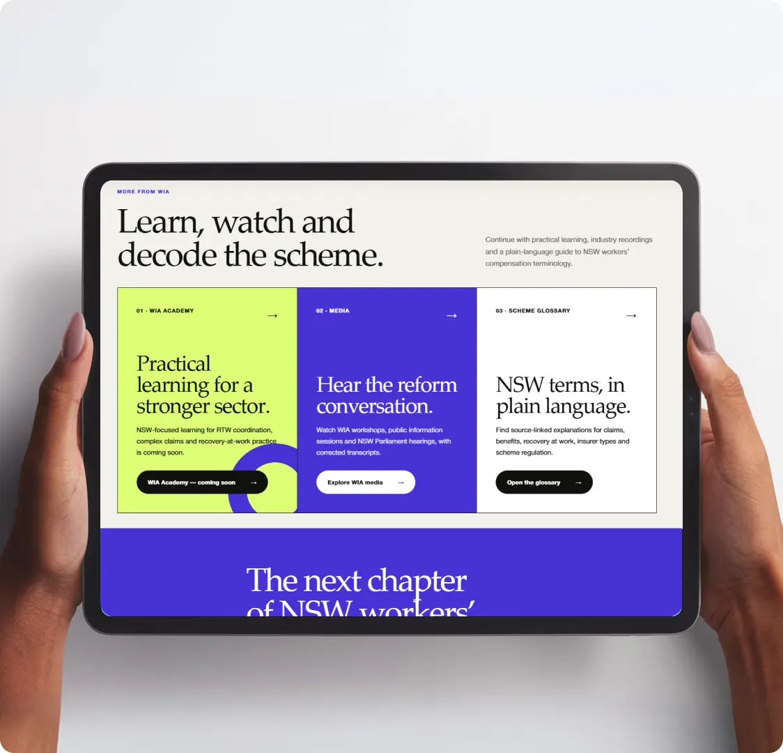 A tablet held in two hands showing the Workers Insurance Association learning section, with three coloured panels for the academy, media and the scheme glossary.
