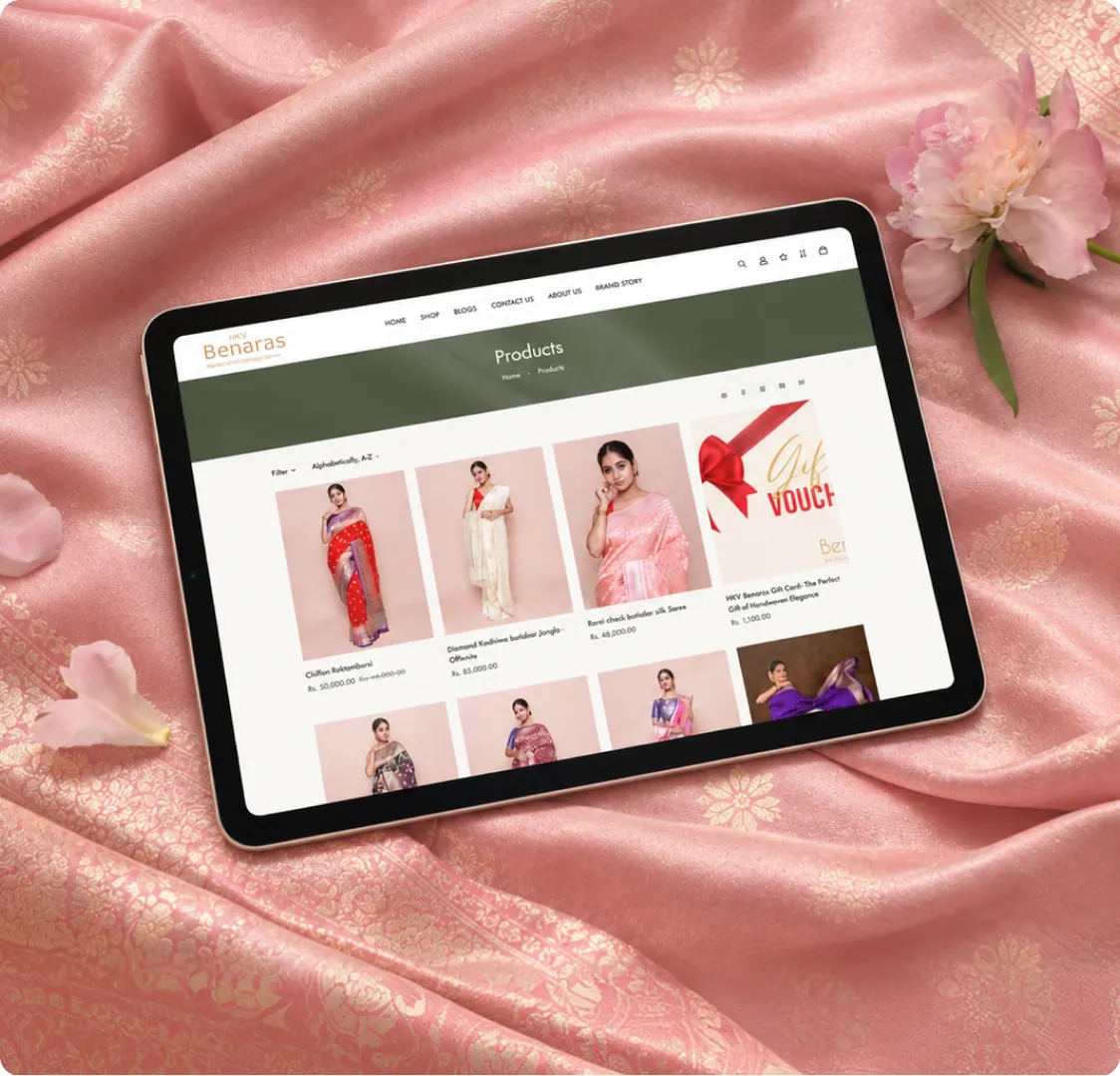A tablet resting on pink fabric, showing the Products page and its grid of items.
