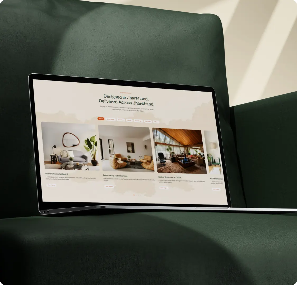 A laptop on a green sofa showing the Tranquil Decor projects section, with location filter buttons above four project cards and their View Project links.