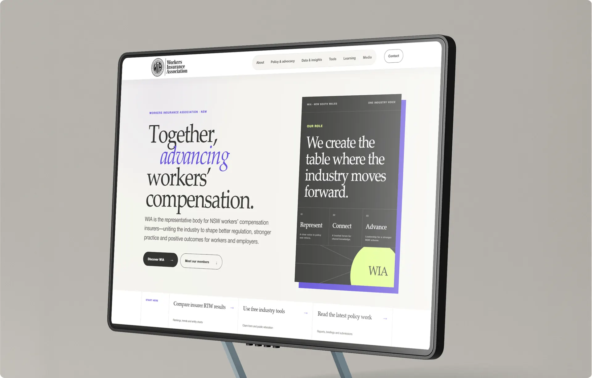 The home page on a monitor, with the headline Together, advancing workers' compensation on the left and a dark Our Role card on the right.