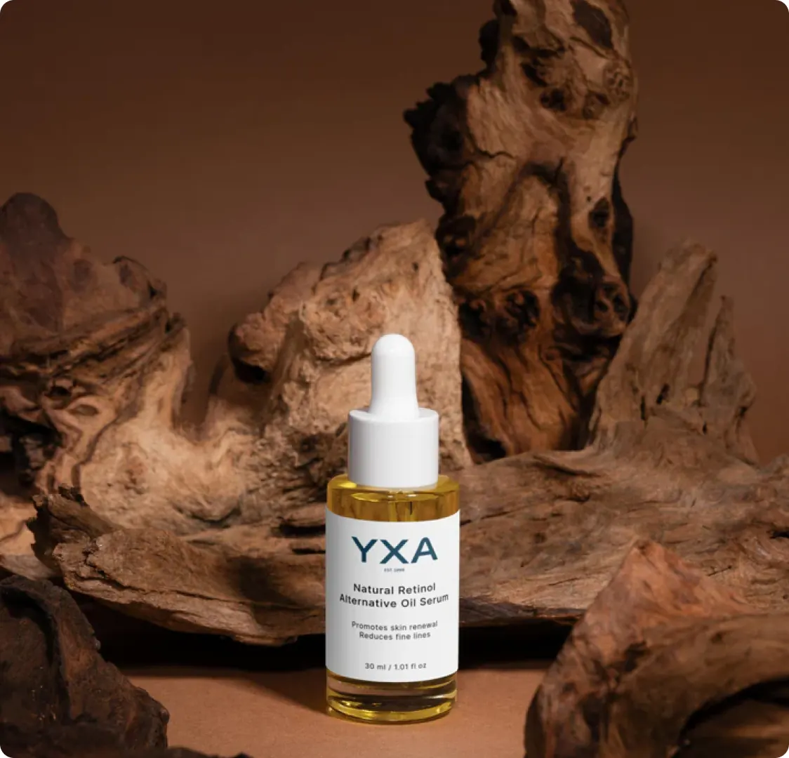 A bottle of the Natural Retinol Alternative Oil Serum standing in front of pieces of driftwood.